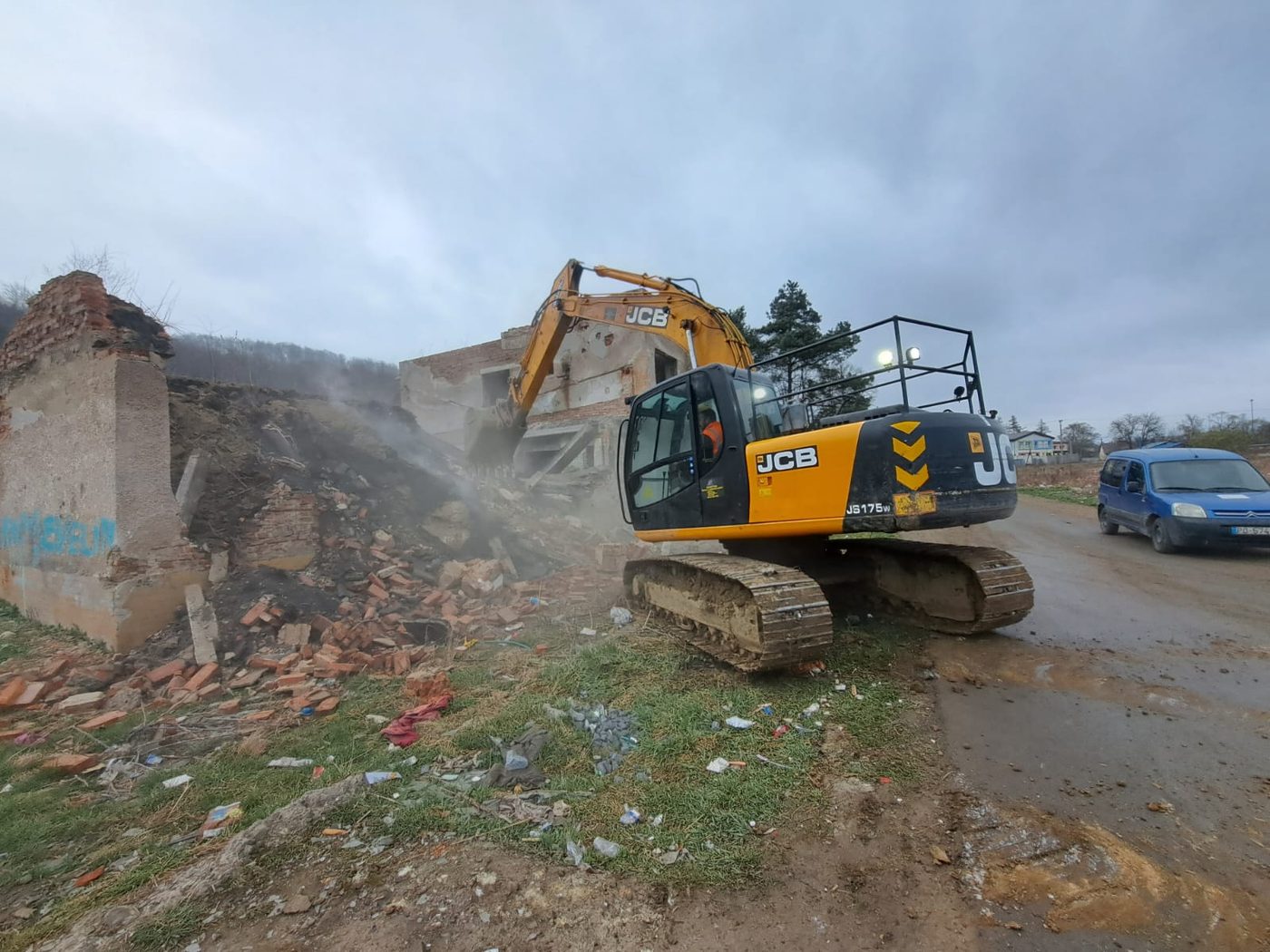 Demolácia tehlovej budovy bagrom JCB